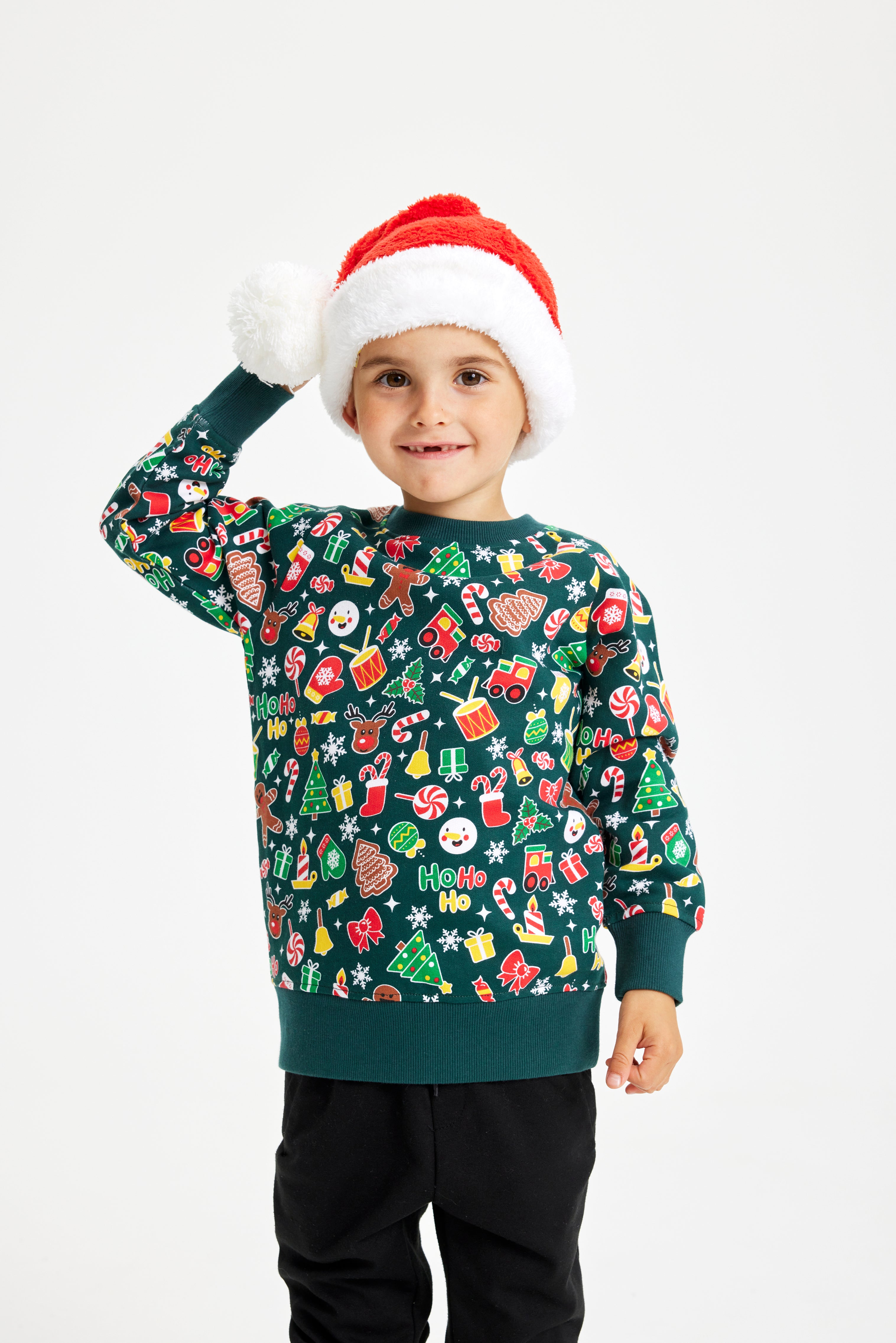 En dreng iført en grøn julesweater og en nissehue.